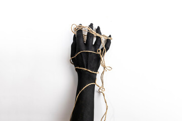 Concept photo with woman hand painted in black paint with a rope wrapping her hand