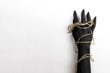 Concept photo with woman hand painted in black paint with a rope wrapping her hand