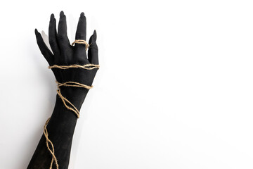 Concept photo with woman hand painted in black paint with a rope wrapping her hand
