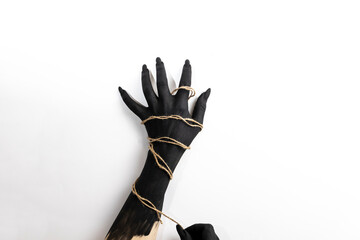 Concept photo with woman hand painted in black paint with a rope wrapping her hand