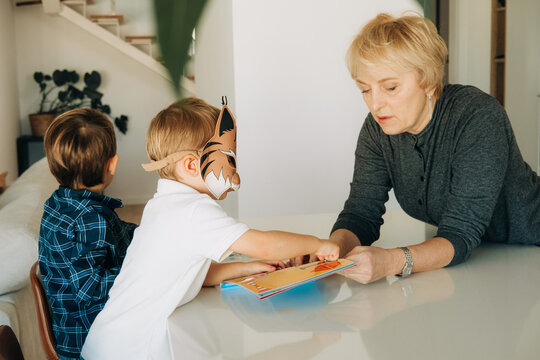 Grandmother Interacting with a Toddler Wearing Tiger Mask at Tab