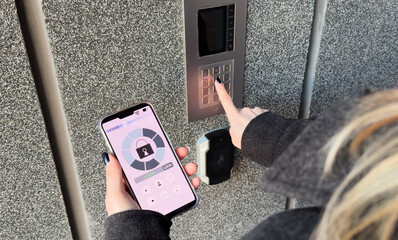 A Person's Hand Holding Smartphone For Disarming Security System Of Door