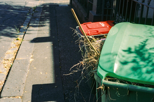 Overflowing green and red bins on the streets of Australia