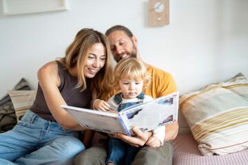 Happy family reading a book together at home