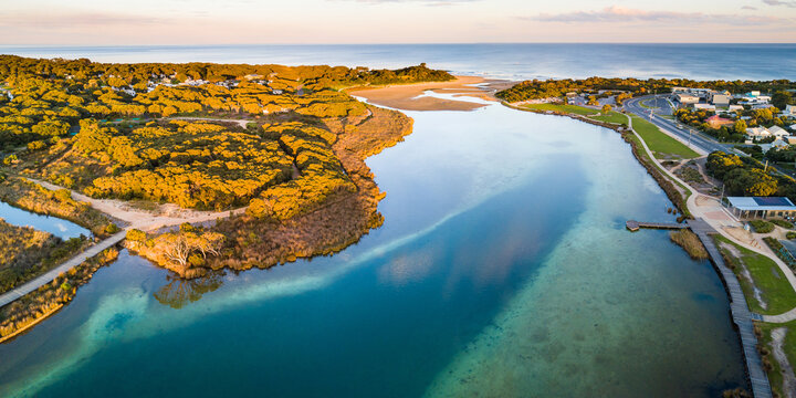 Golden sunshine on a coastal river flowing to the ocean