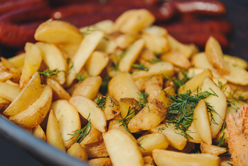 fried potato frying in large pan outdoors, street food concept