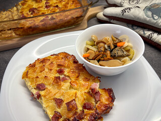 Pasta baked with smoked meat and bowl of pickled mushrooms