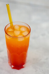 Refreshing Orange Carbonated Drink with Ice Cubes in Tall Glass on Gray Surface, Trendy Dirty Soda Concept