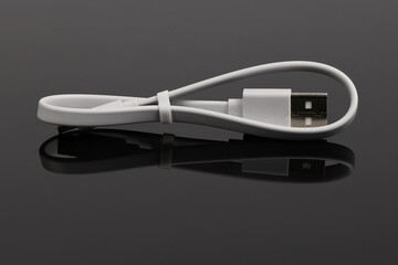 White USB cable on black acrylic background. High resolution photo.