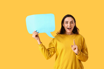 Young woman with blank speech bubble on yellow background
