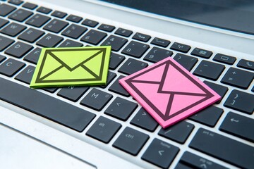 The sticky note with a black outline of an envelope on a laptop keyboard. Email and communication...
