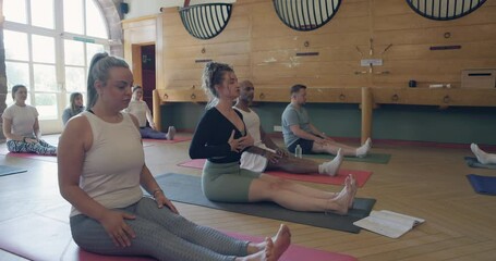 Stretching, coaching and fitness with teacher in yoga studio for meditation, health and workout. Wellness, spiritual and exercise with group of people in class for pilates, mindfulness and relax