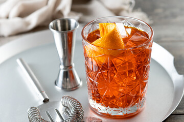 Americano cocktail garnished with twist orange on wooden table