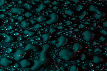 Gotas de agua de color verde con reflejos rojos