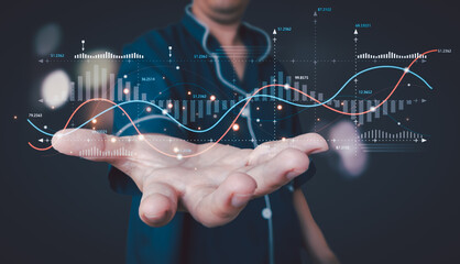 Man in pajamas holding out a hand with glowing holographic financial graphs, charts, and data visualizations, symbolizing data analysis, investment, and digital finance.