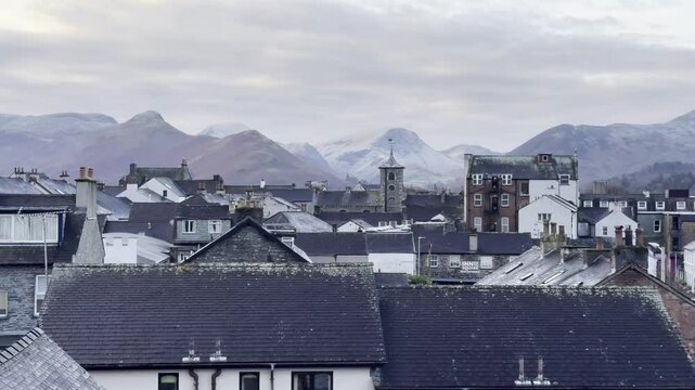 Scenic landscape of Keswick with snowy fells in the background on a quiet winter morning - Lake District, UK
