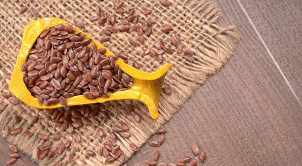 Brown flax seed or linseed on wooden background. Diet healthcare healthy food.