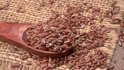 Brown flax seed or linseed on wooden background. Diet healthcare healthy food.