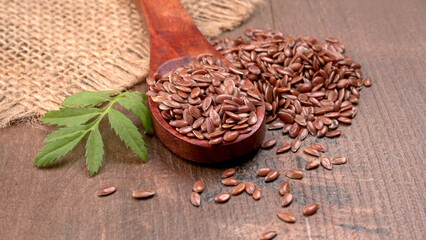 Brown flax seed or linseed on wooden background. Diet healthcare healthy food.