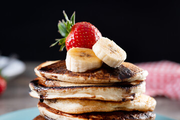 Pancakes with chocolate and fruit on wooden table. Close up