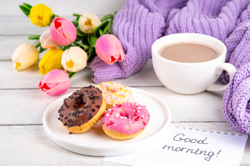 Small sugar glazed donuts with coffee latte cup, tulip flowers, sweater and tulip flowers