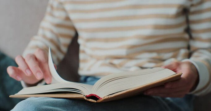 Young woman reading book in cozy living room, turning page, learning, studying, education, read books, stay home concept.