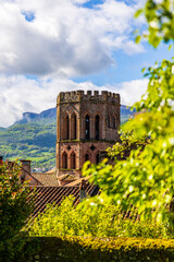 Romanesque cathedral of Saint-Lizier and its hexagonal brick bell tower with the green mountains of...