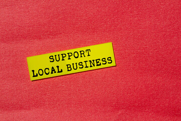 Support local business message written on yellow paper label on red background. Conceptual support...