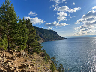 Scenic view of lake baikal in autumn with dramatic sky and forested coastline for nature and travel...