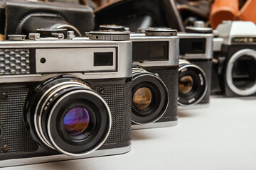 Vintage film cameras in various designs and styles arranged with leather cases, showcasing the...
