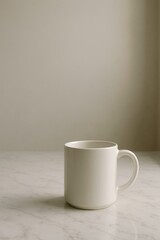 Obraz premium A white ceramic mug placed on a marble surface with soft lighting, ideal for a minimalistic lifestyle shot.