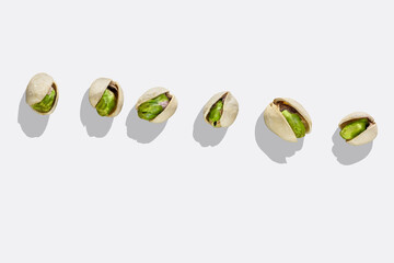 Pistachio nuts isolated on white background. Top view. Roasted green pistachios in open shells on white background with shadow.