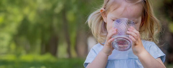 little girl drinking water from a glass