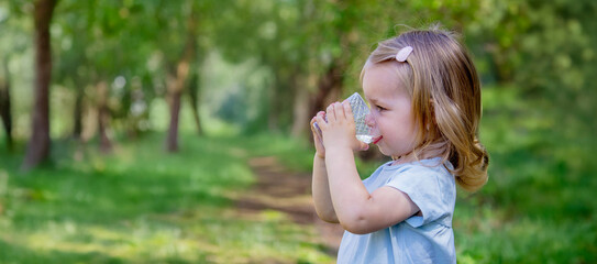 little girl drinking water from a glass