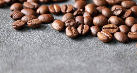 Roasted coffee beans against a gray background.
