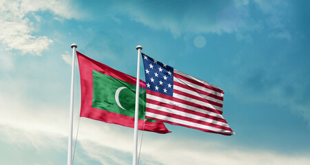 Maldives and America friendship flags are waving in the sky.Two country flag for agreement or deal. Maldives USA national flag for comittment.