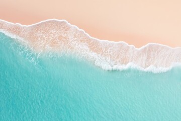 Aerial view of turquoise waves gently washing onto a sandy beach with foamy surf.