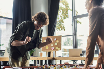 Team members celebrate a victory during a lively game in a modern office space
