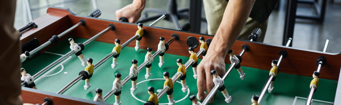 Engaging in a spirited foosball match to foster team spirit and collaboration in a modern office