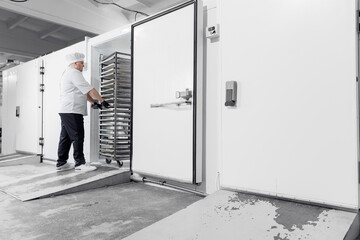 Male caucasian adult technologist freezing puff pastry in industrial confectionery production line