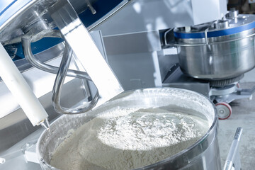 Dough mixing process in confectionery industry, automated machines preparing puff pastry ingredients