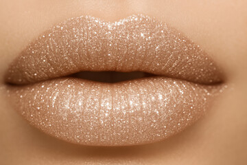 Fototapeta premium Close-up of glossy nude lips covered in golden glitter, showcasing luxurious and glamorous lip makeup.