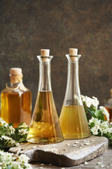 Bottles of herbal tincture with fresh hawthorn flowers in spring