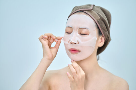 Young Woman Applying Sheet Face Mask for Hydration and Beauty