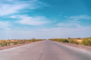 A long road with a clear blue sky above it