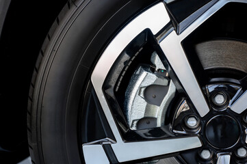 Car wheel with brake calipers and stylish design.