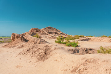 A desert landscape with a hill in the background