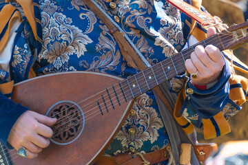 Renaissance musician playing lute in ornate costume close-up