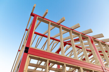 Constructing a wooden and steel frame structure against clear sky