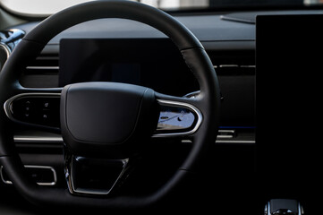 A close-up of a modern car's steering wheel with control buttons